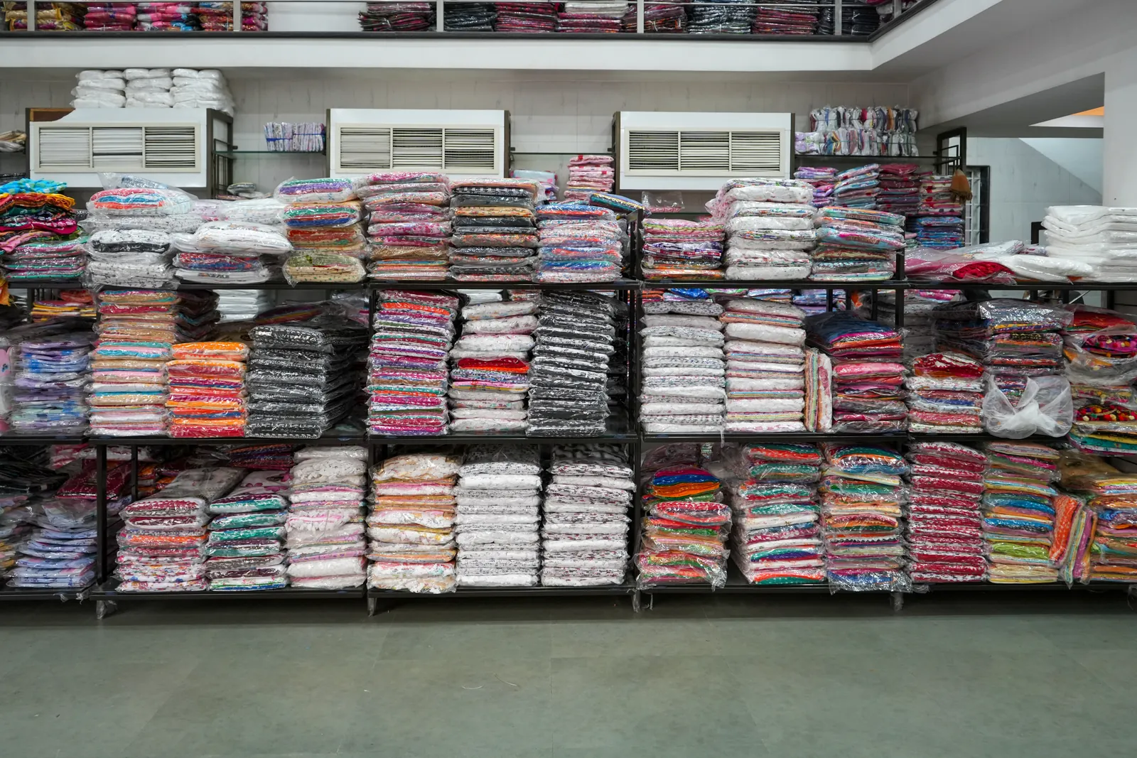 Apsara Textiles ka stock, rangbirangi maal stack mein
